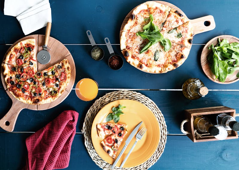 Party setup with multiple deep dish pizzas and sides at Pequod's